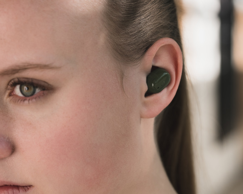 a lady listening to music with a black nokia e3200 essential wireless headphone