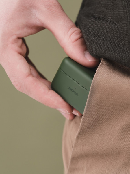 a men putting a green nokia E3200 essential true wireless earphones into his pocket