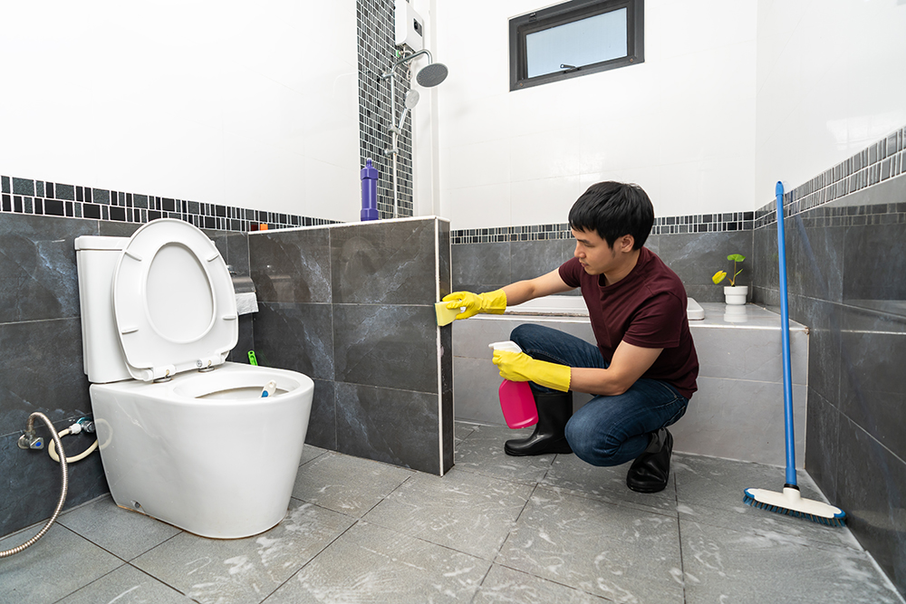 young-man-cleaning-bathroom-home