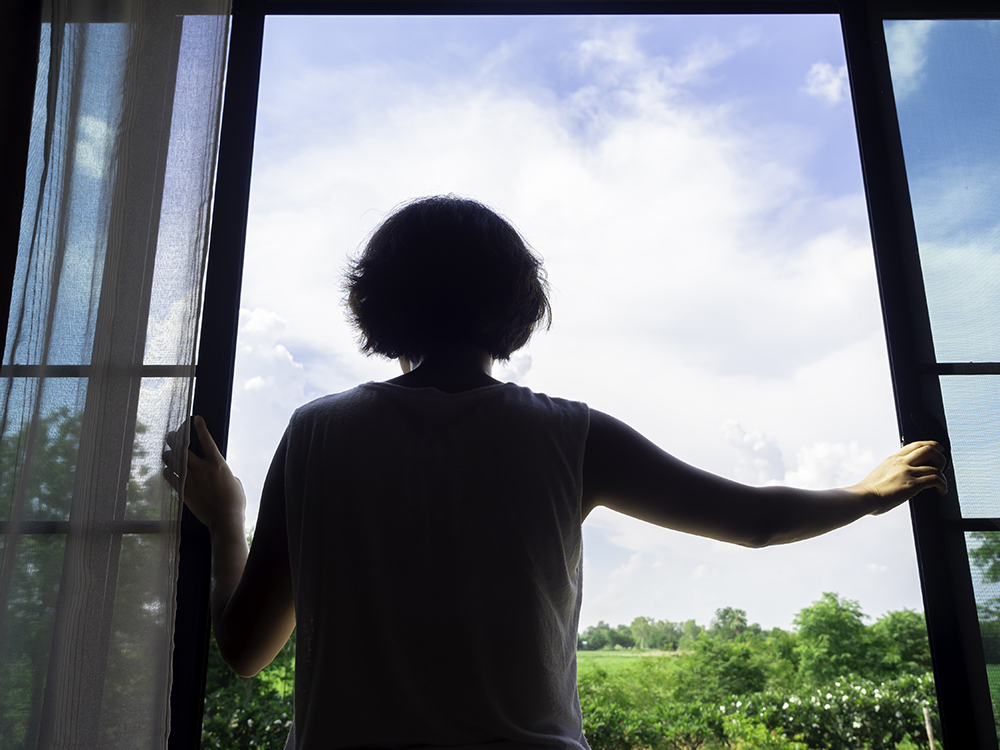 image-back-woman-short-hair-opening-large-glass-window-bedroom-second-floor-house-looking-out-green-landscape-blue-sky-sunny-day.jpg