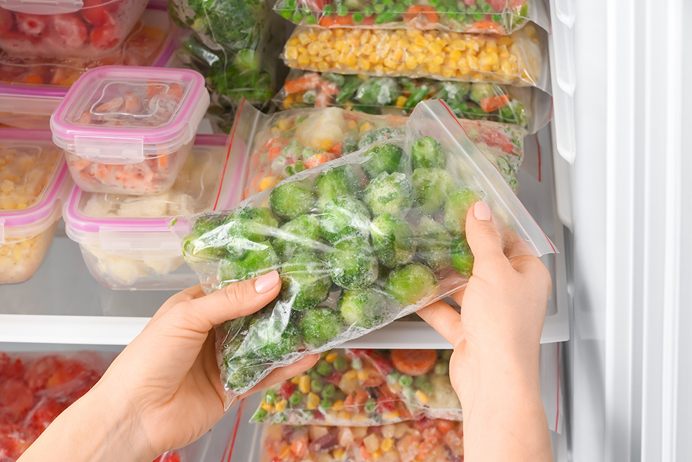 woman-putting-plastic-bag-with-frozen-vegetables-into-refrigerator.jpg