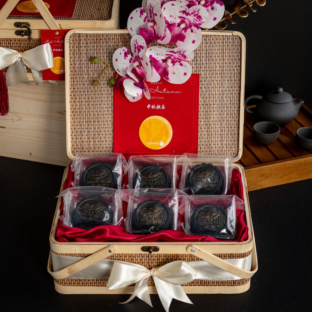 Baked charcoal durian lava mooncake with pandan paste and lotus seed in a repurposable bamboo wooden gift picnic basket and orchid flower 9