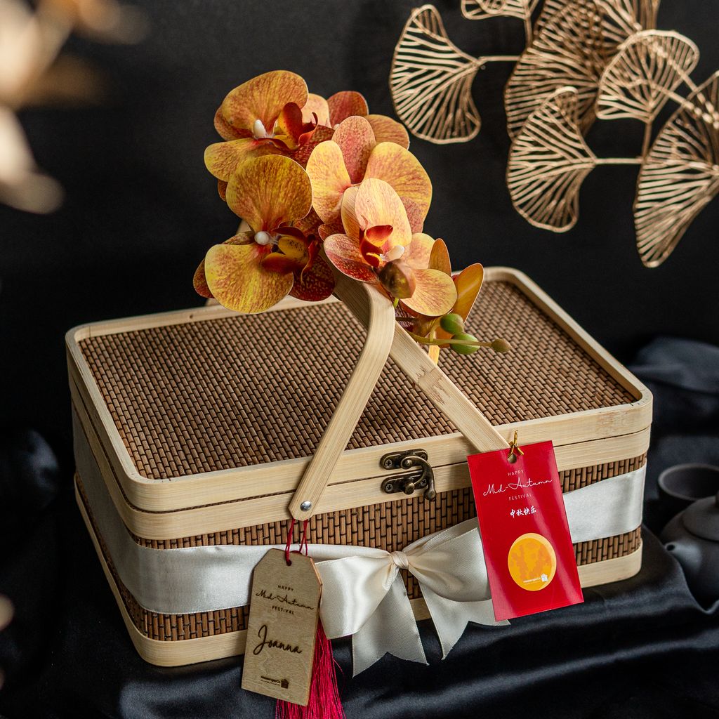 Baked charcoal durian lava mooncake with pandan paste and lotus seed in a repurposable bamboo wooden gift picnic basket and orchid flower 10