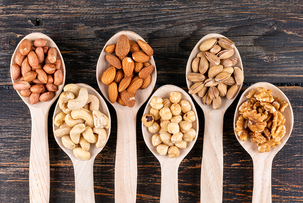 some-assorted-nuts-dried-fruits-with-pecan-pistachios-almond-peanut-cashew-pine-nuts-wooden-spoons.jpg