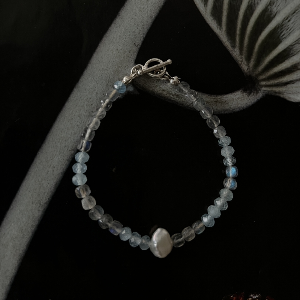 Matilda & Co. Mystic blue 方塊藍光拉長石與鑽切海藍寶手鍊，點綴天然巴洛克珍珠。搭配925純銀OT扣設計，深色背景下襯托出深海般的平靜光澤與靈感能量。