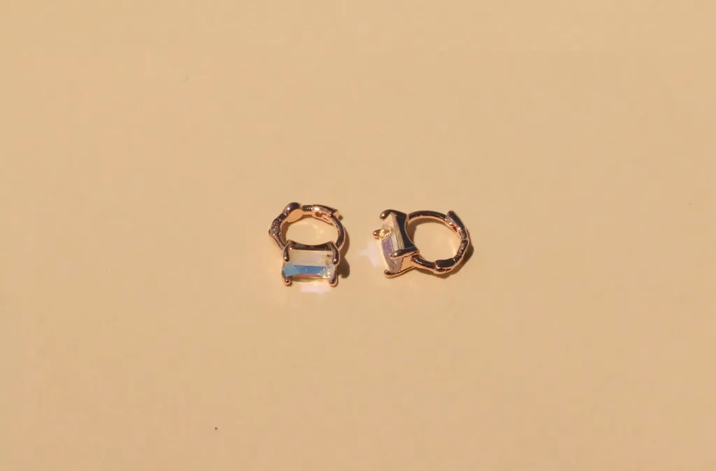 Claire玫瑰金鋯石耳環，簡約設計，中間嵌有切割藍色鋯石，在柔光中閃耀