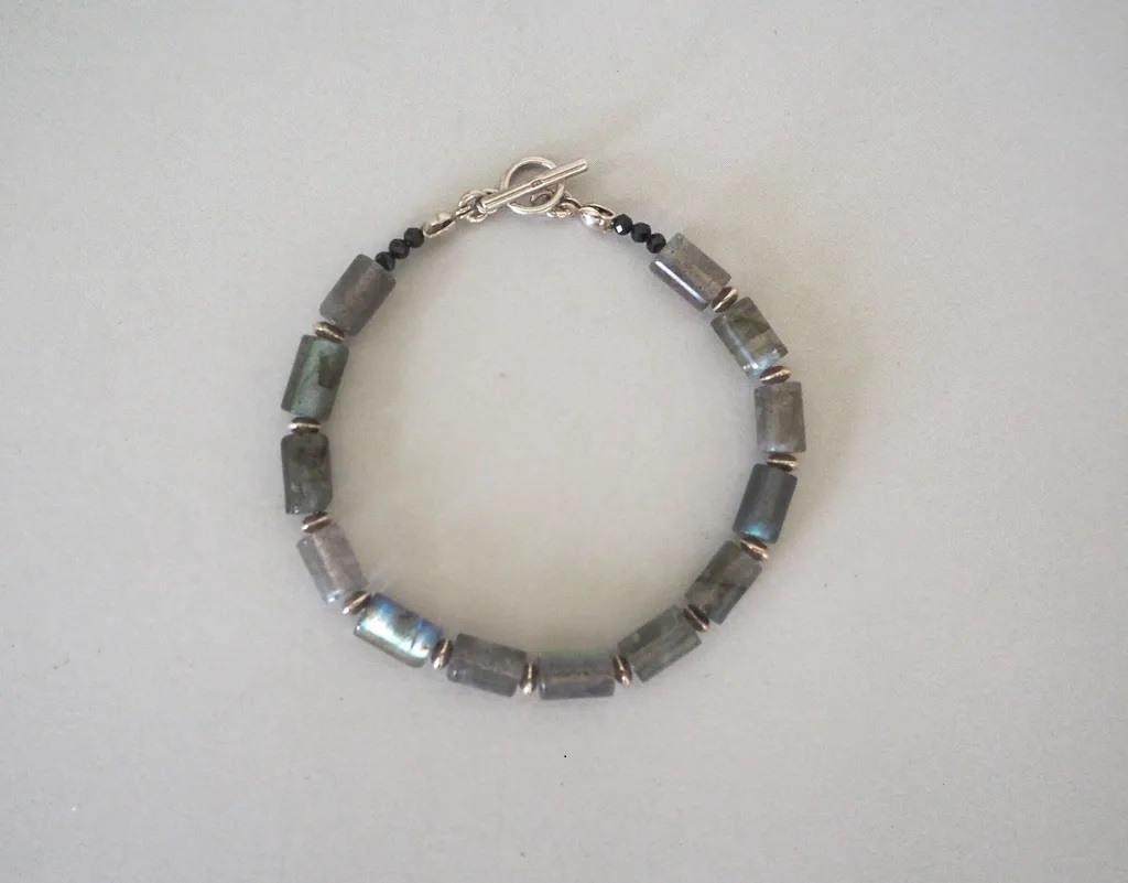 Roxane手鍊以圓柱狀拉長石與黑色尖晶石組成，搭配淺色背景特寫圖