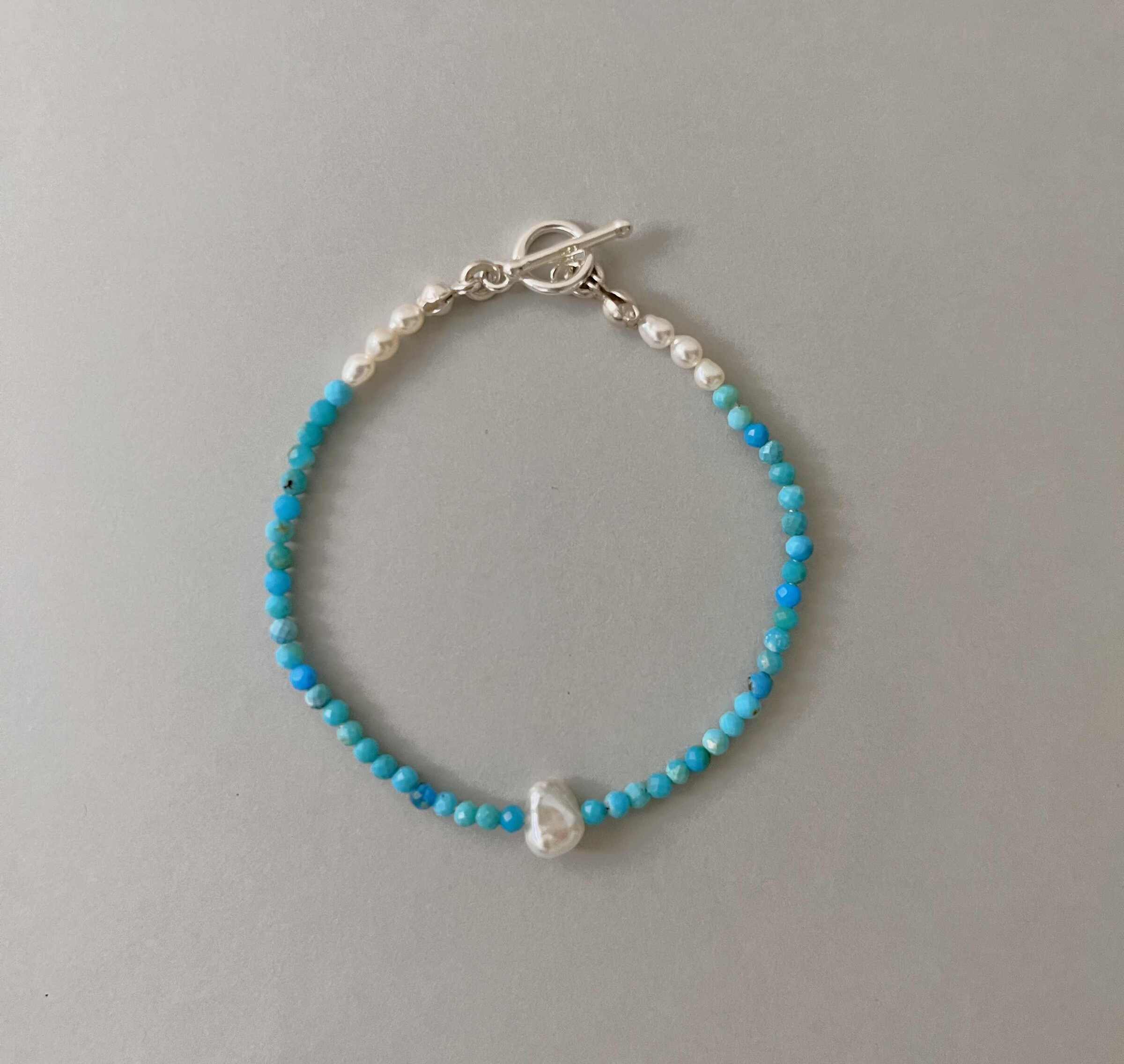 Sierra手鍊由亞利桑那藍色綠松石與米粒珍珠串成，點綴一顆巴洛克珍珠.