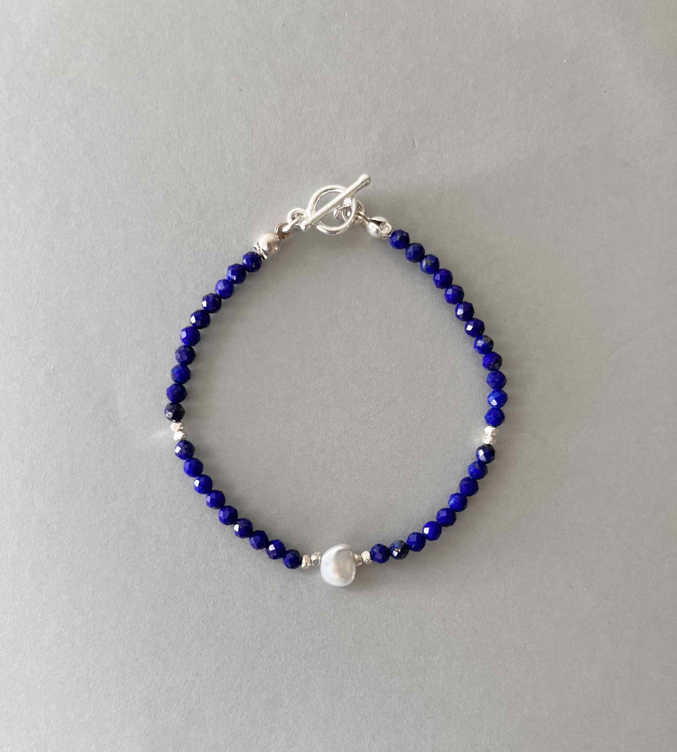 arielle青金石珍珠手鍊，由深藍色青金石、銀珠與不規則巴洛克珍珠組成，採用 OT 扣設計，展現優雅風格。