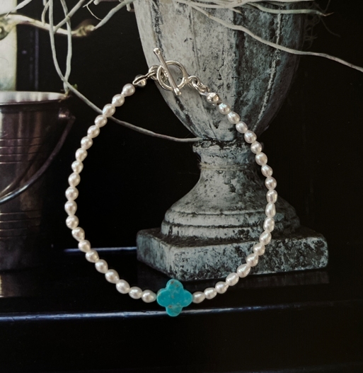 綠松石雕刻而成的四葉幸運草與米粒珍珠串成的手鍊，象徵幸運與溫柔守護。