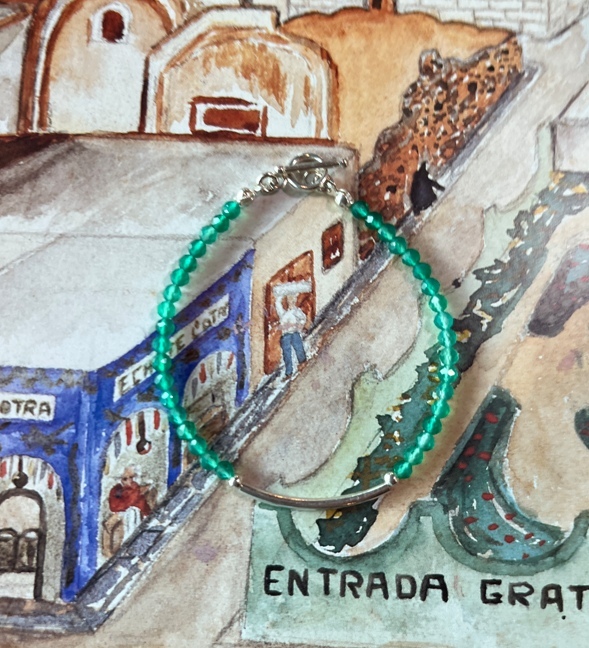 varane綠鉻透輝石手鍊，搭配銀色弧形管珠與 T 字扣設計，晶瑩翠綠的寶石珠串成簡約優雅的風格，象徵智慧與心靈平衡。