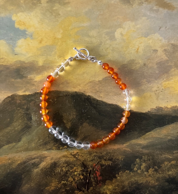 這條紅玉髓搭配白水晶的手鍊，展現暖橘光感，象徵行動力與清晰的方向，適合想突破停滯、提升自信的人。
