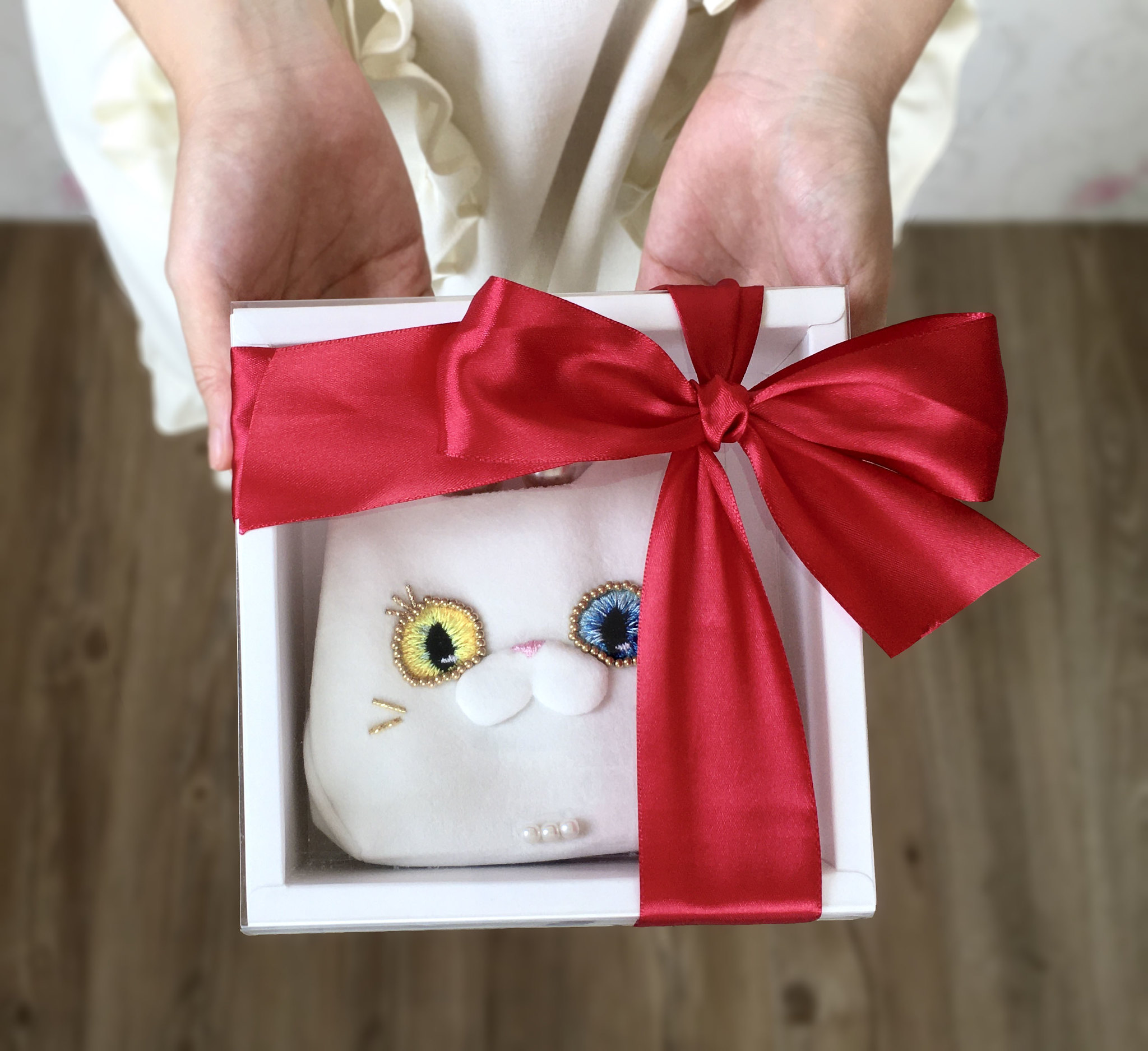 異色瞳白貓夫人短夾以透明蓋的白色紙盒包裝並有紅色緞帶蝴蝶結