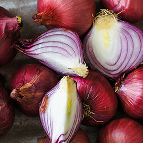 Red onion on the wooden background with knife