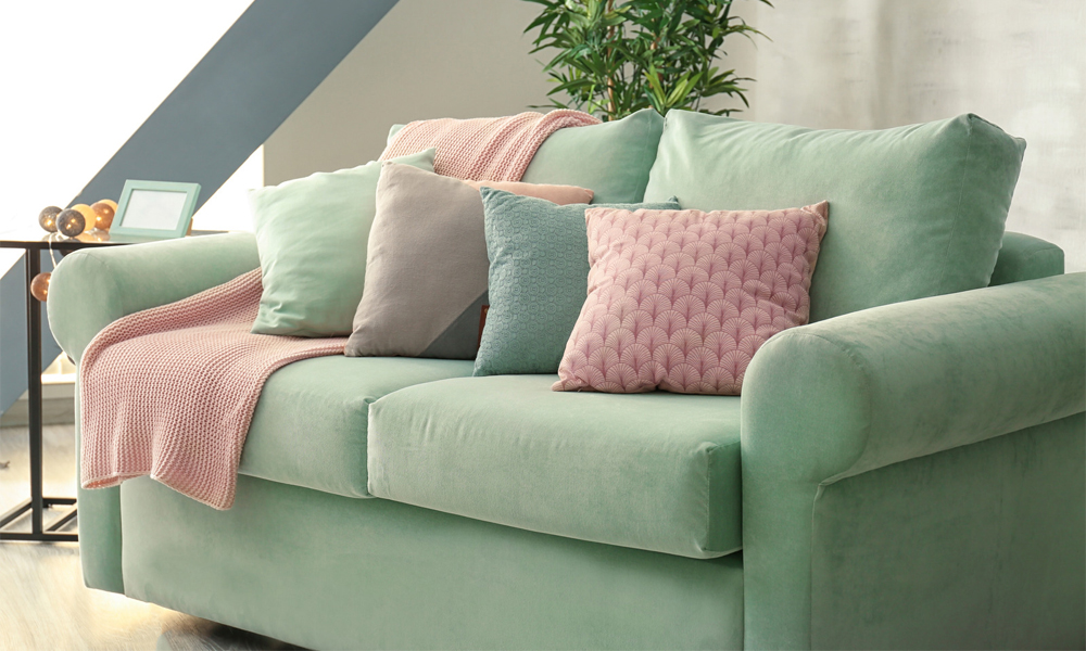 Pastel green lawson sofa with pink throw pillows