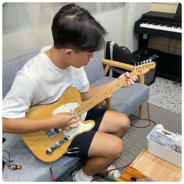 學生在教室沙發上練電吉他