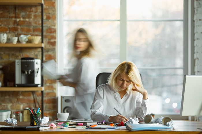 nervous-tired-boss-her-workplace-busy-while-people-moving-near-blurred-office-worker-manager-working-has-problems-deadline-her-colleagues-distracting-business-work-workload-concept