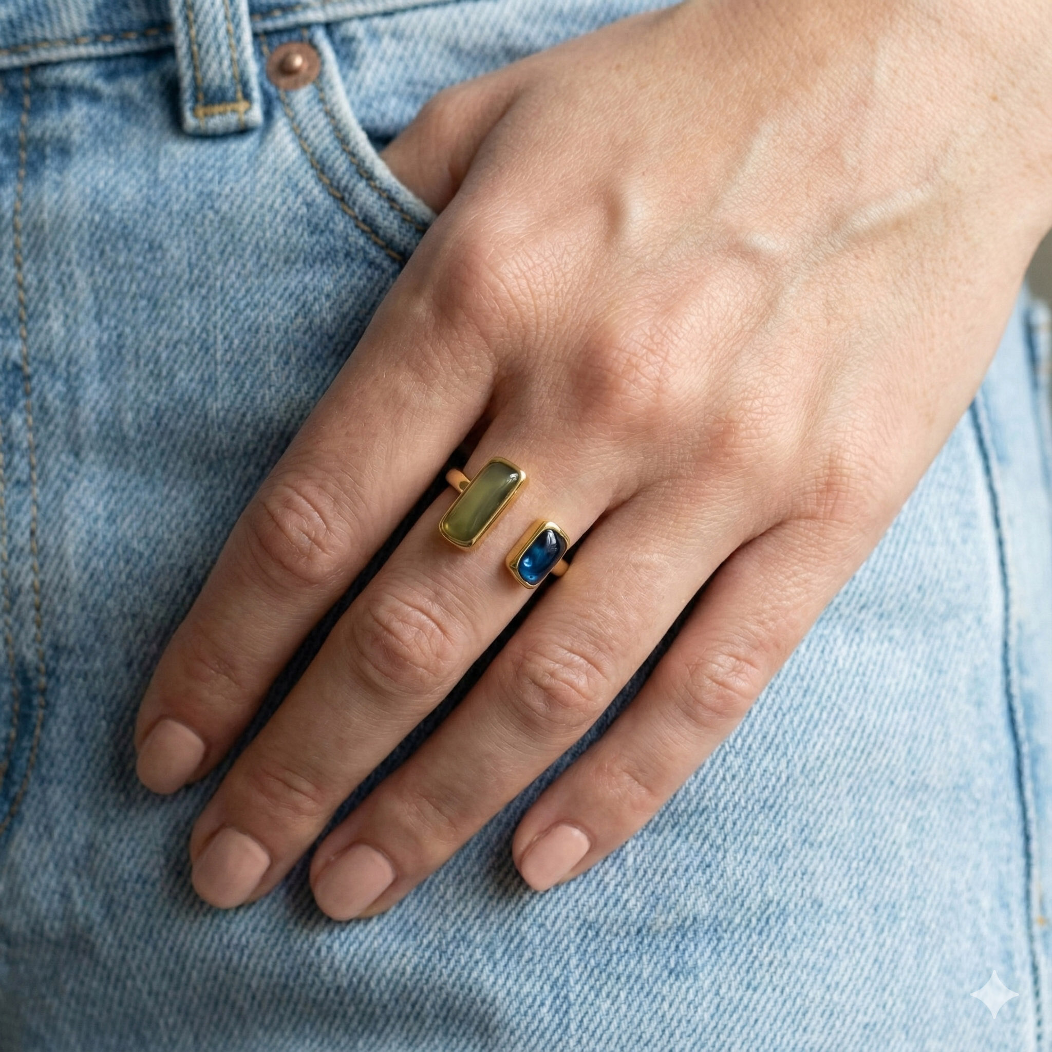 綠藍雙石開口戒指實際配戴示意,金色戒台,手部自然放在牛仔褲口袋旁