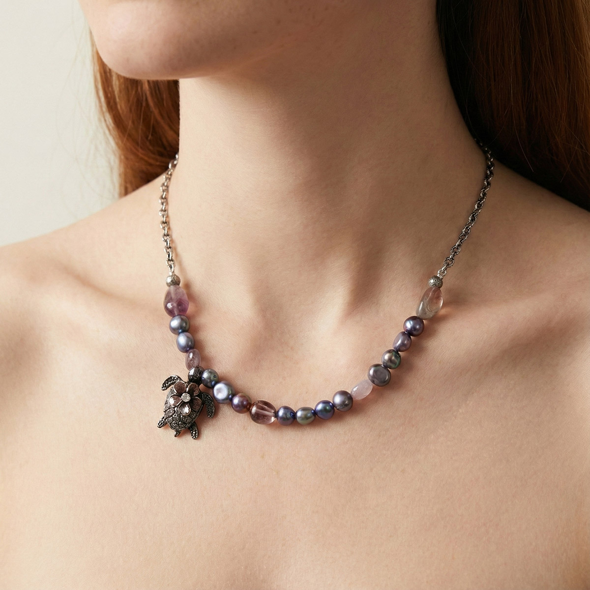模特兒佩戴極光黑珍珠海龜項鍊,彩色珍珠沿鎖骨自然垂墜,展現低調優雅的海洋守護風格