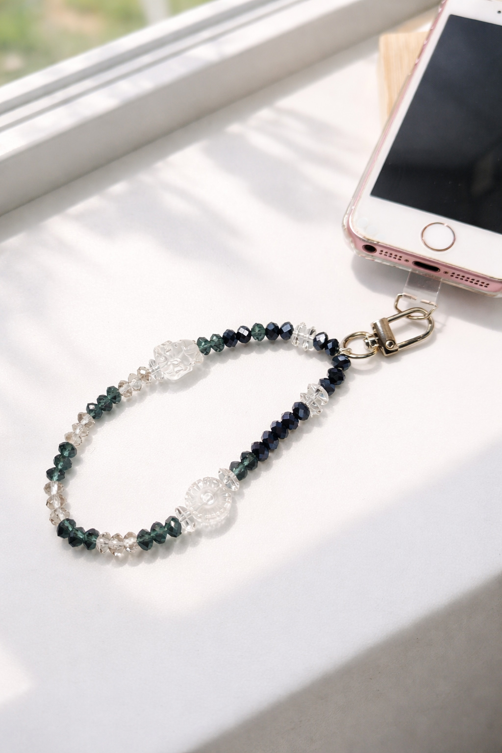 天然白水晶九尾狐雪花手機掛繩手腕款實際使用情境,連接手機殼配戴於手腕,透明水晶搭配深色切面珠,日常外出方便攜帶