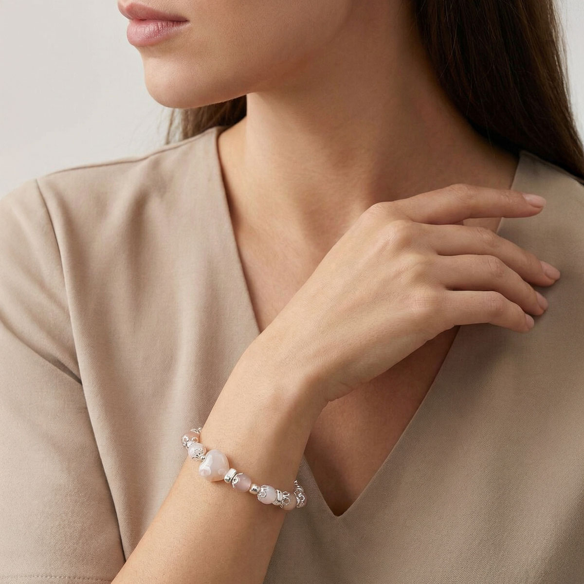 模特兒手腕配戴晨曦櫻花晶彩光橙月石手鍊,粉橙色系水晶在自然光下呈現溫潤光感,適合日常穿搭