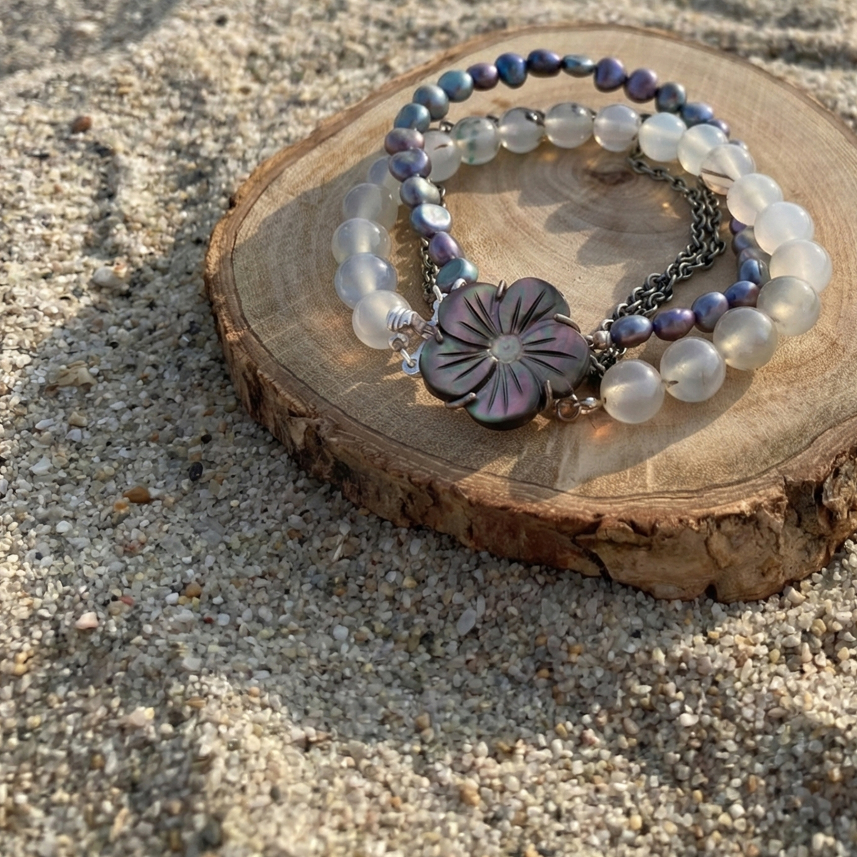 深海灰珍珠海洋玉髓雙鍊置於沙灘自然場景，呈現溫潤光澤與海洋氣息