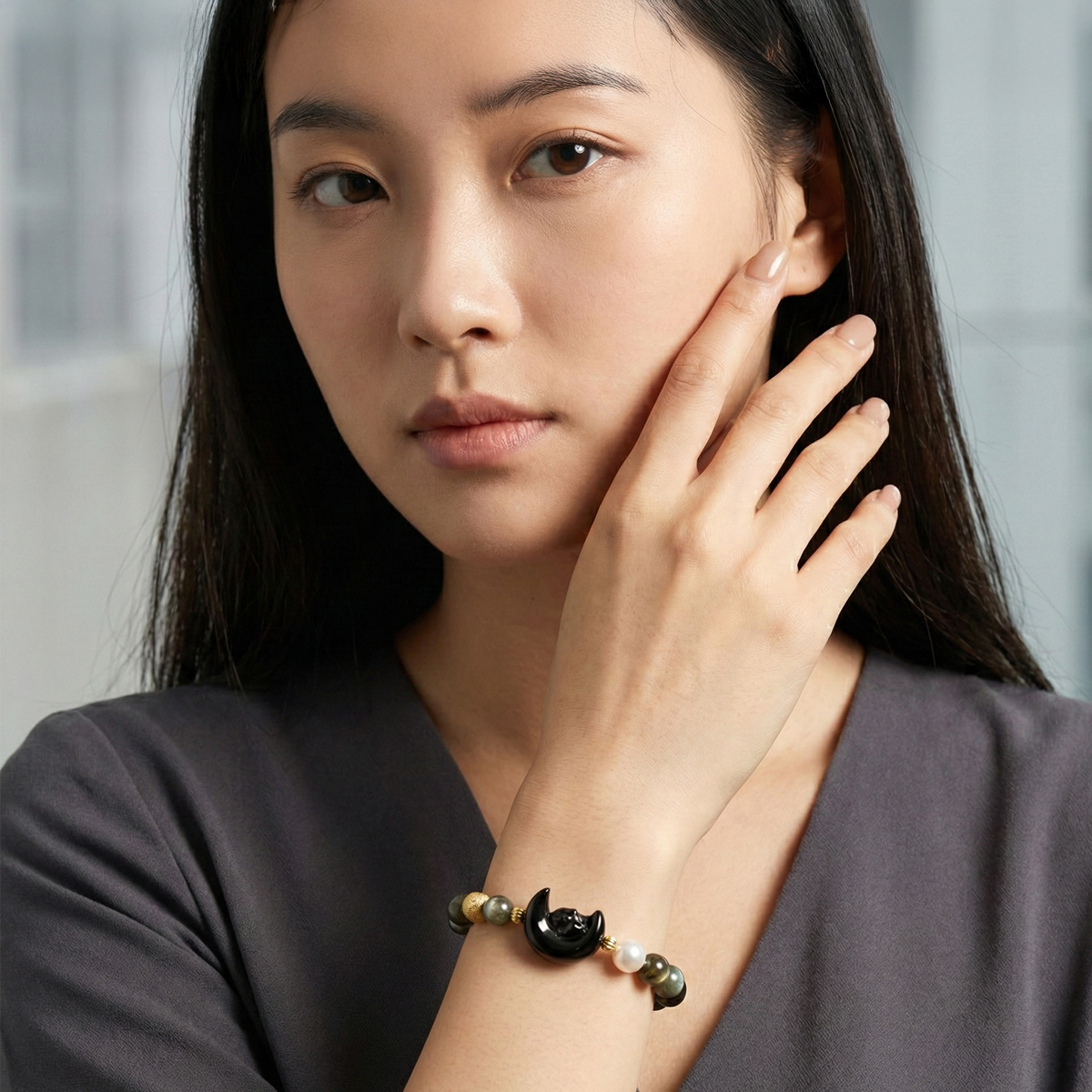 真人女性配戴黑曜月兔珍珠拉長石手鍊,深色拉長石與黑曜月兔墜飾呈現沉穩內斂的日常穿搭氛圍