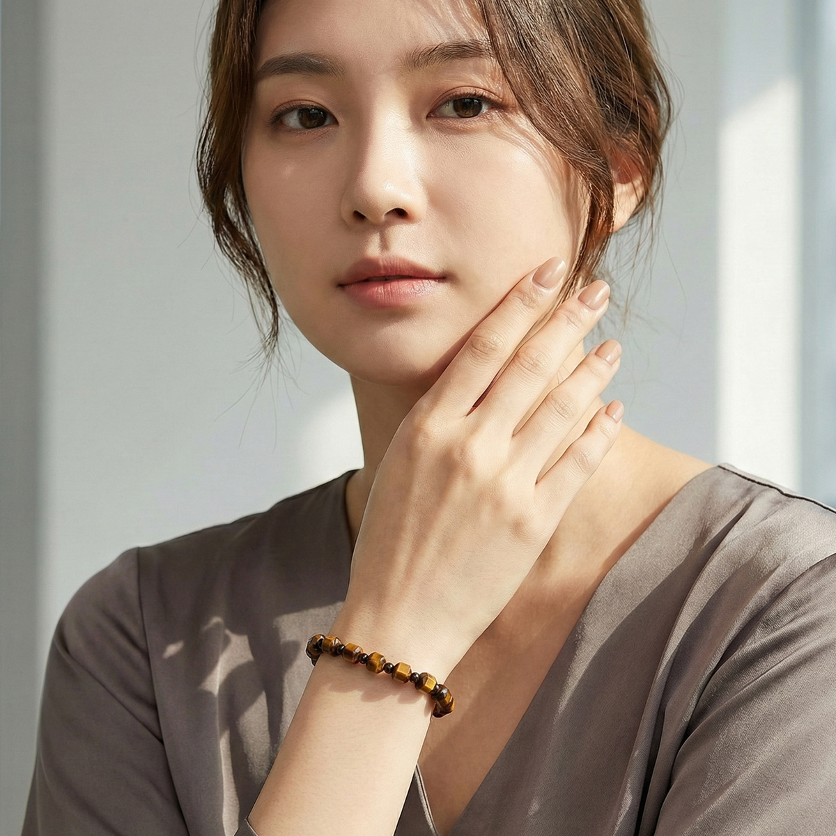模特兒自然光下配戴金曜虎眼石六角切面手鍊，深金棕色虎眼石與中性色服裝搭配，呈現低調質感風格