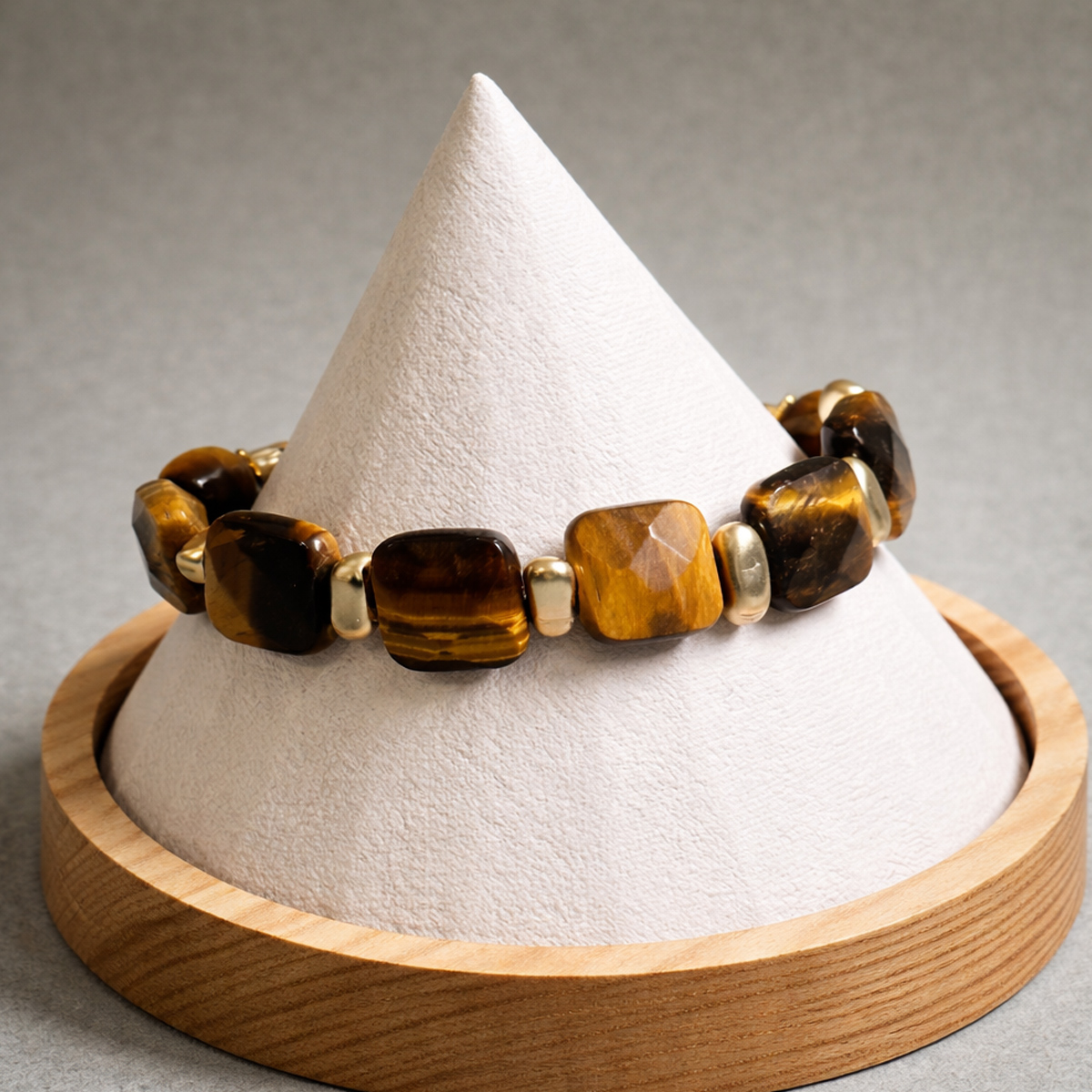 琥珀光芒虎眼石手環置於展示座上,突顯方形虎眼石切面與金色配件細節