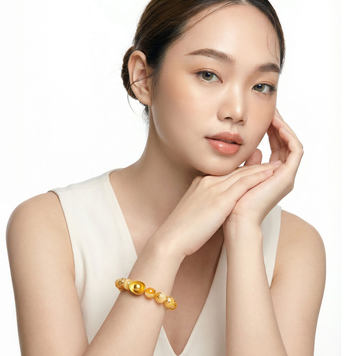 模特於純白背景中配戴暖陽黃玉元寶手鍊,黃玉珠光柔和,搭配金色元寶設計,展現優雅且沉穩的日常佩戴風格