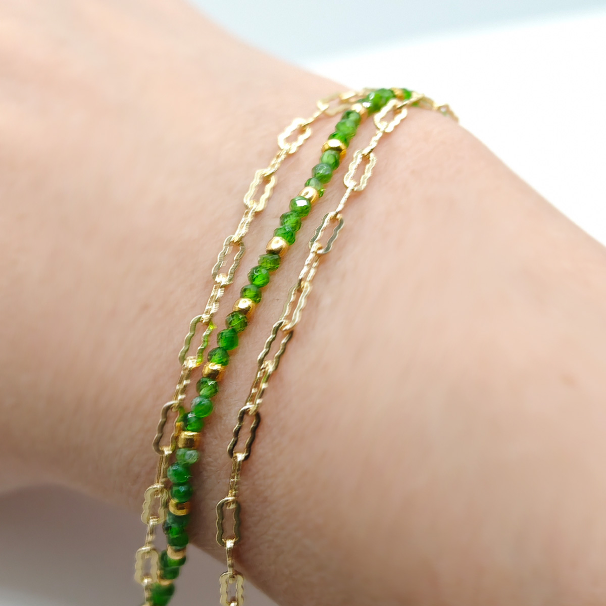 綠碧璽金質極細鍊手鍊手腕近拍,綠色切面碧璽串珠搭配細緻金鍊,呈現貼合肌膚的輕盈層次感