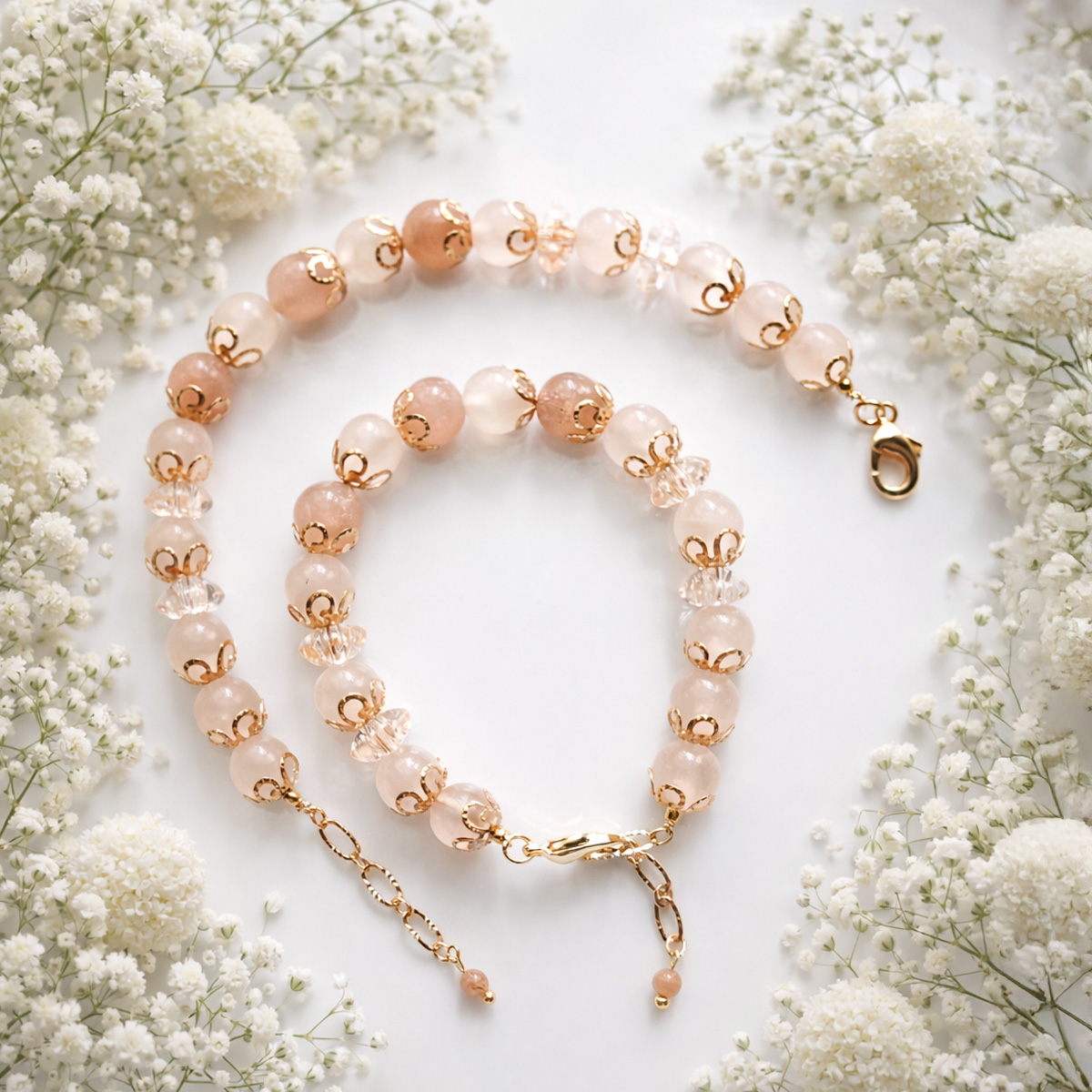 金橙月光石柔光蕾絲手鍊花藝情境圖，白色滿天星襯托溫柔色調