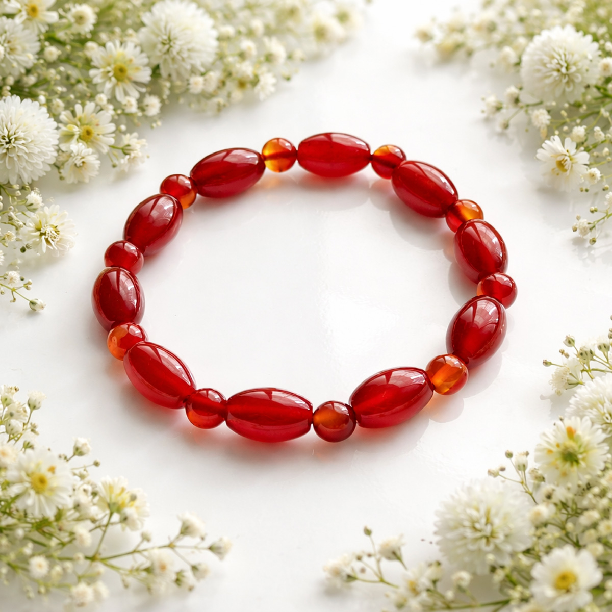 溫潤紅瑪瑙髓橢圓珠串手鍊,搭配白色小花點綴,展現柔和療癒的生活風格情境