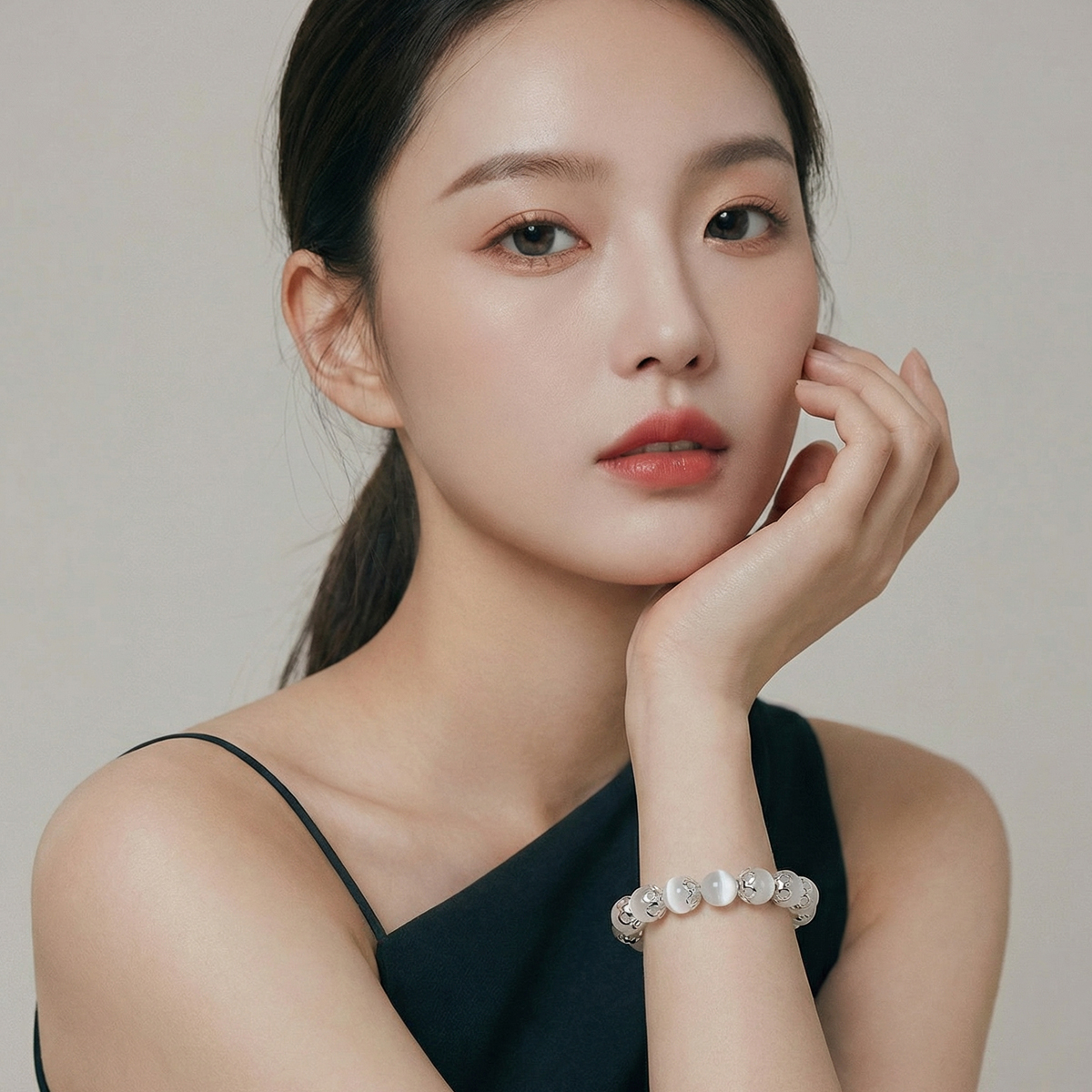 雪紗白貓眼石白玉髓手鍊搭配簡約深色服裝配戴於手腕，白色貓眼珠與銀色隔珠呈現優雅、乾淨的日常佩戴風格。