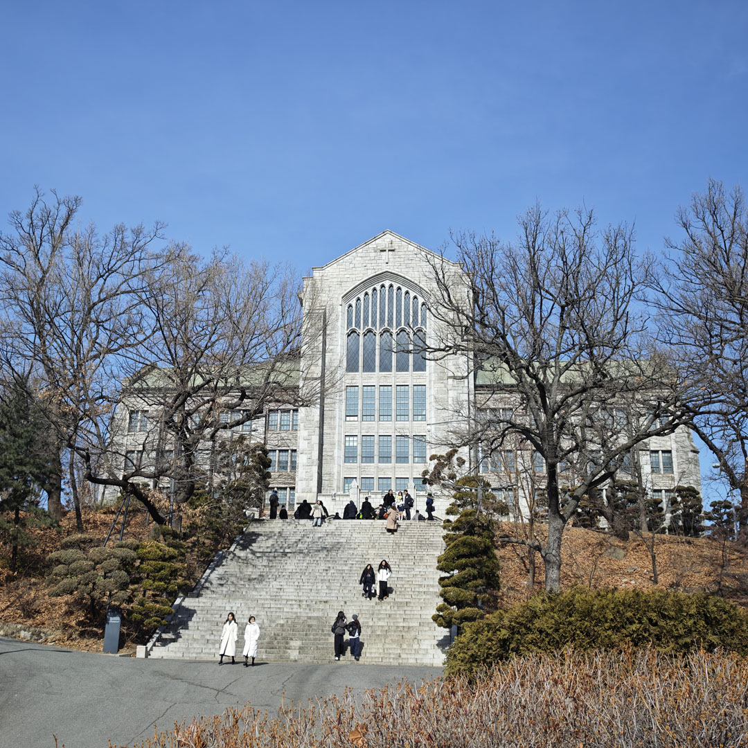 首爾梨花女子大學階梯與石造主建築，冬季藍天與落葉景色，GD FAM 見面會旅程開場的城市風景