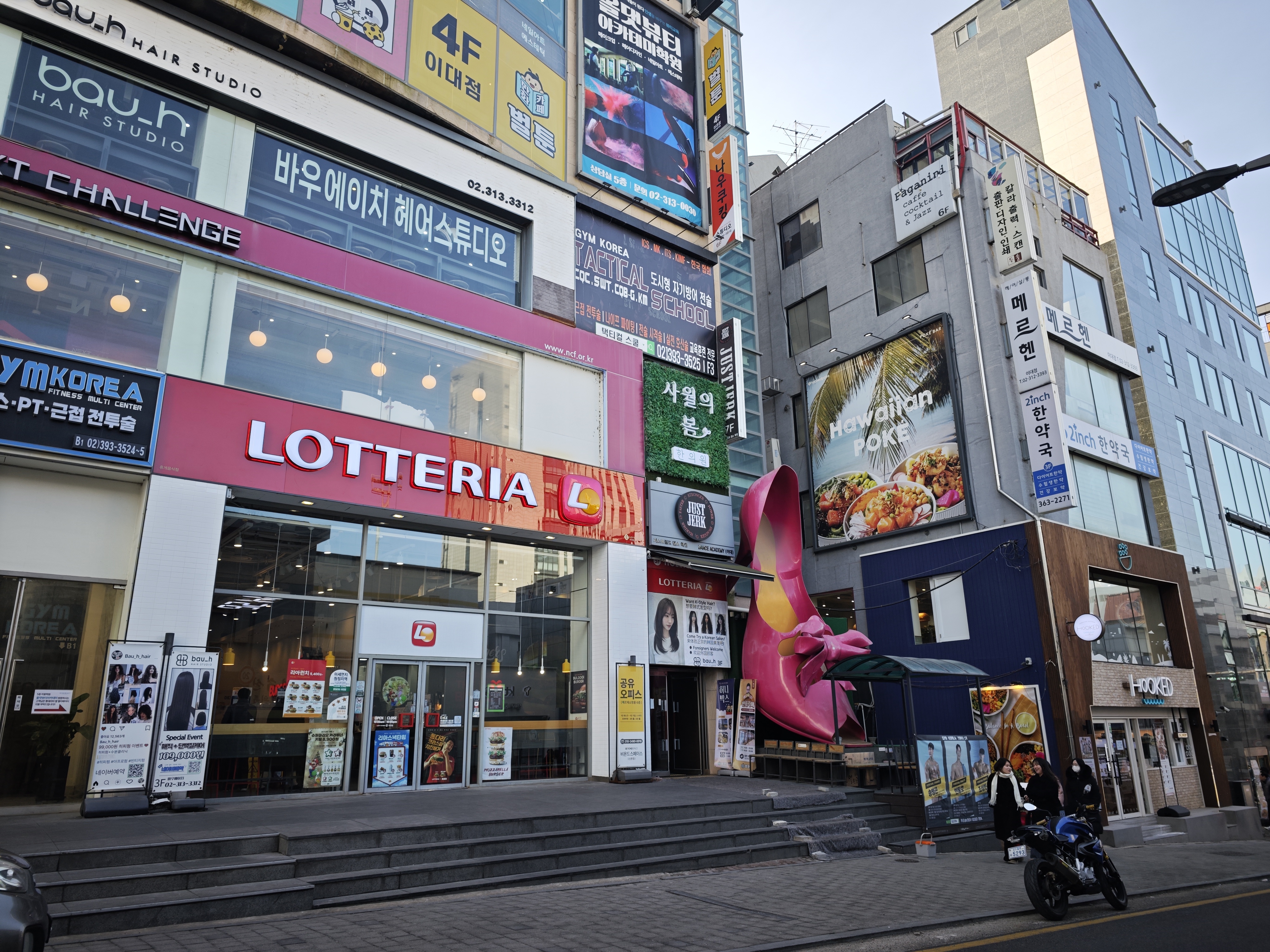 首爾梨大女人街商圈街景與 LOTTERIA 招牌，服飾與餐飲店鋪林立，GD FAM 見面會三天二夜旅程第一天城市紀錄