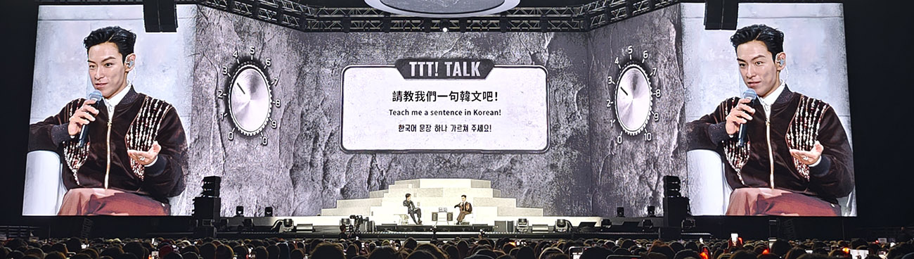 香港場「TTT! TALK」單元畫面,T.O.P 手持麥克風受訪,螢幕上顯示中英韓三語提問卡「請教我們一句韓文吧」