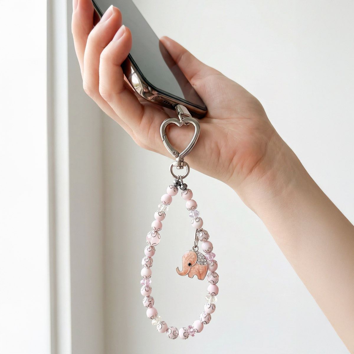 gentle-guardian-pink-shell-elephant-phone-strap-in-hand